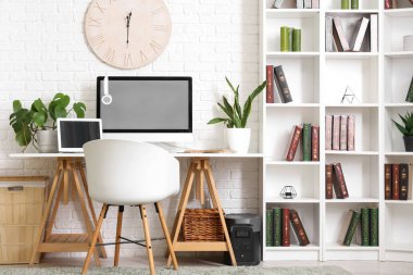 Çalışma yeri, modern bilgisayar, sandalye ve kitaplığı olan şık bir ofis.