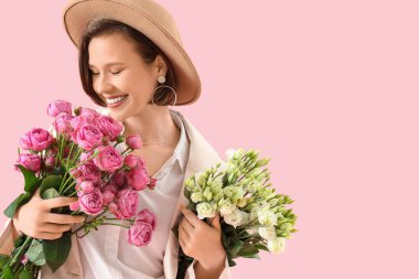 Pembe arka planda çiçekleri olan güzel bir genç kadın, yakın plan.