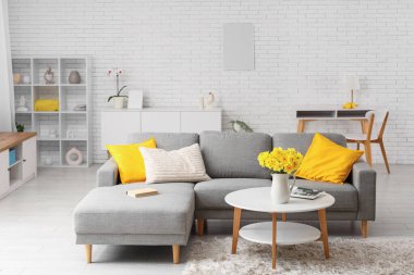 Şık oturma odasının içinde kanepe ve nergis çiçekli kahve masası var.