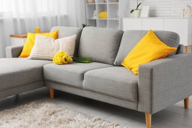 Odadaki kanepede bir buket nergis çiçeği.