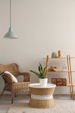 Hasır koltuklu, sehpalı ve çiçekli şık bir oturma odası.