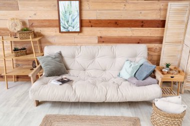 Rahat kanepe, rattan sepet ve sehpası olan şık bir oturma odası.