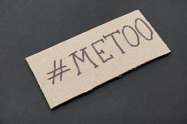 Cardboard paper with hashtag METOO on dark background