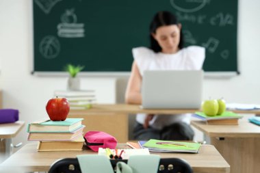 Sınıfta masa başında kitap olan elma, yakın plan.