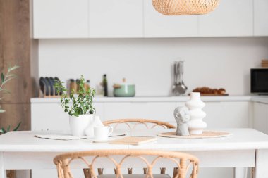 Çiçek, vazo ve defter yemek odasındaki masada.