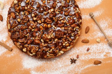 Farklı fındıklı tatlı tart ve kahverengi arka planda karamel.