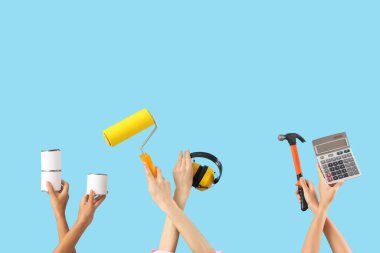 Mavi arka planda mimar malzemeleri olan kadınlar.