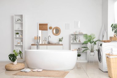 Banyonun içinde küvet, çamaşır makinesi ve hasır paspas var.