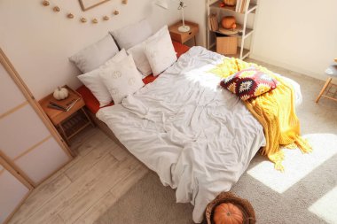 İçinde raf ünitesi ve balkabağı olan rahat bir yatak odası.