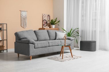 Konforlu kanepe, kahve masası ve pouf oturma odasının içinde.