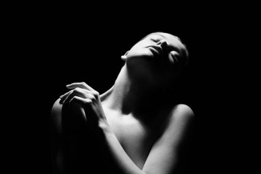 Karanlık arka planda genç bir kadının silueti, yakın plan.