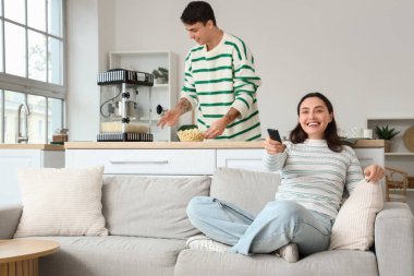 Modern patlamış mısır makinesi olan sevimli bir çift evde film izliyor.