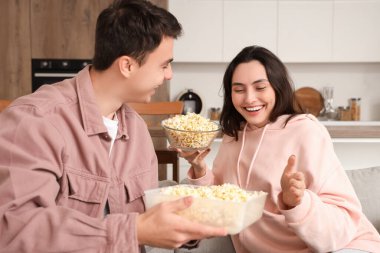 Evdeki kanepede taze patlamış mısırlı şirin bir çift oturuyor.