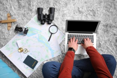 Haritası ve dizüstü bilgisayarı olan genç bir turist eve dönüş yolculuğunu planlıyor. Güzergah kavramı