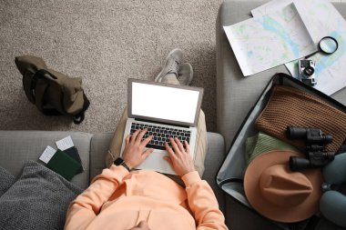 Dizüstü bilgisayarı, bavulu ve haritası olan genç bir turist eve dönüş yolculuğunu planlıyor. Güzergah kavramı