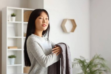 Gri ekose elbiseli genç Asyalı kadın.