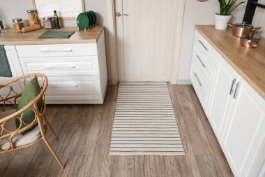 Tezgahı ve beyaz kapısı olan şık bir mutfak.