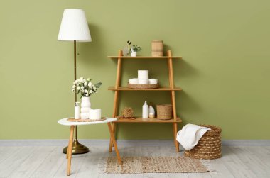 İçinde çiçekler, banyo aksesuarları ve raflarda rulo tuvalet kağıdı olan şık bir banyo.