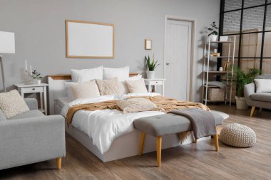 Şık bir yatak odası, rahat bir yatak, kanepe ve beyaz bir kapı.