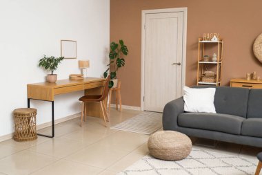 Gri kanepe, hasır puf ve beyaz kapılı şık bir oturma odası.