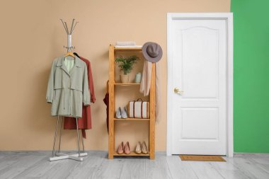 Rafları, askılığı ve beyaz kapısı olan şık bir koridorun içinde.