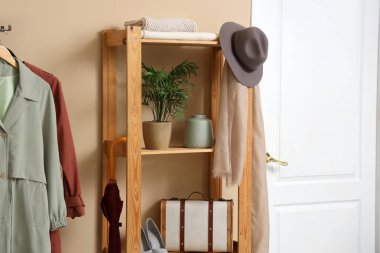 Rafları, askılığı ve beyaz kapısı olan şık bir koridorun içinde.