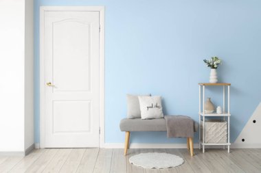 Gri banklı, raf üniteli ve beyaz kapılı şık bir koridor.