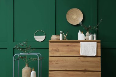 Banyonun içinde okaliptüs dalları, çekmeceler ve raf ünitesi var.