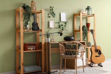 Çalışma yeri, raf üniteleri ve müzik aletleri olan stüdyonun içi