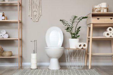 Tuvaletin içinde klozet, masa ve raf ünitesi var.