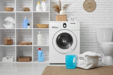 Modern çamaşır makinesi, raf ünitesi, klozet ve deterjan şişeleriyle şık bir çamaşır odası.
