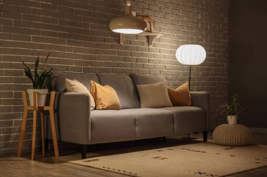 Rahat kanepesi ve parlak lambaları olan modern oturma odası.