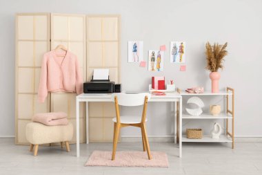 Modern yazıcı ve dizüstü bilgisayarlı giyim tasarımcısının işyeri