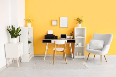 Modern yazıcı ve dizüstü bilgisayarı olan işyeri şık bir ev ofisinde.