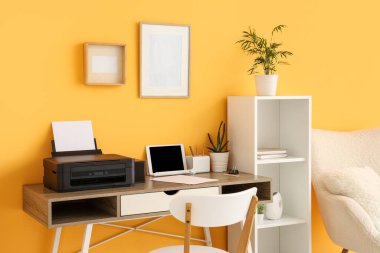 Modern yazıcı ve dizüstü bilgisayarı olan işyeri şık bir ev ofisinde.