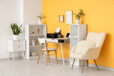 Modern yazıcı ve dizüstü bilgisayarı olan işyeri şık bir ev ofisinde.