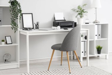 Modern yazıcı, cep telefonu ve dizüstü bilgisayarı olan şık bir iş yeri