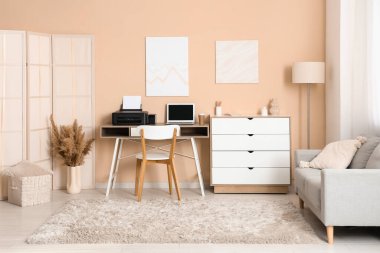 Modern yazıcı ve dizüstü bilgisayarı olan işyeri şık bir ev ofisinde.