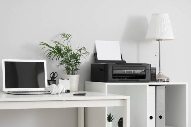 Modern yazıcı ve dizüstü bilgisayarı olan şık bir iş yeri