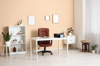 Modern yazıcısı, dizüstü bilgisayarı ve şık ev ofisinde rahat koltuğu olan işyeri