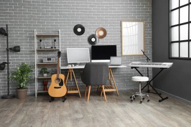 Çalışma yeri, raf ünitesi ve müzik aletleriyle kayıt stüdyosunun içi