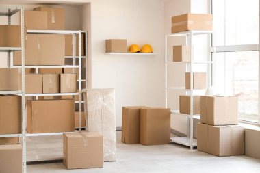 Raf üniteleri ve karton kutularla dolu hafif deponun içi.