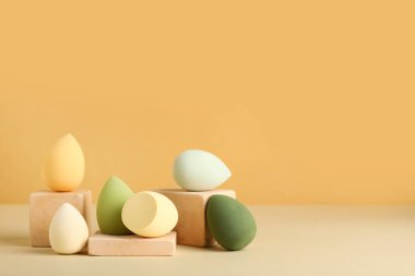 Bej arka planda makyaj süngeri olan dekoratif podyumlar