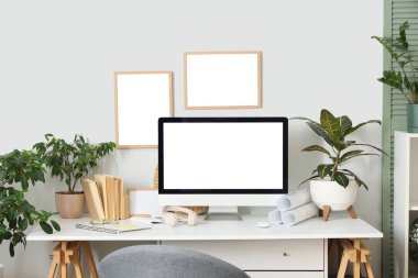 Rahat çalışma alanı, modern bilgisayar ve ev bitkilerine sahip şık bir ofis.