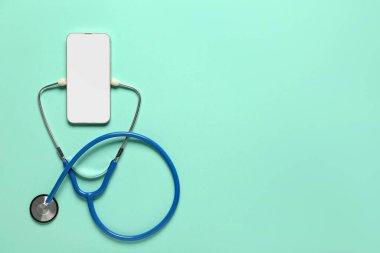 Turkuaz arka planda cep telefonu ve steteskop