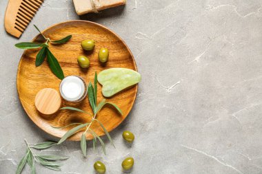 Doğal kozmetik ürünleri, spa aksesuarları ve grunge arka planında yeşil zeytinli kompozisyon