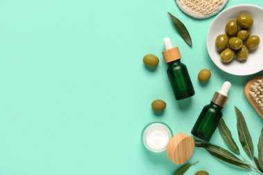 Renkli arka planda doğal kozmetik ürünleri, spa aksesuarları ve yeşil zeytinlerle kompozisyon