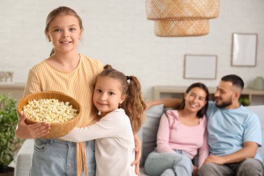 Patlamış mısırları ve evde aileleri olan sevimli kız kardeşler.