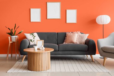 Kanepesi, masası ve boş çerçeveleri olan şık bir oturma odası.