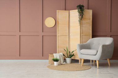 Gri koltuklu, katlanır perdeli ve bitkilerli şık bir oturma odası.